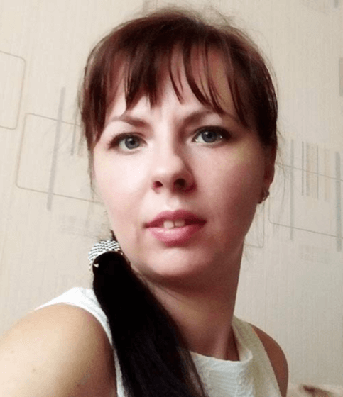 (Ольга Смирнова) Женщина с темно-каштановыми волосами и челкой. Волосы собраны в хвост.